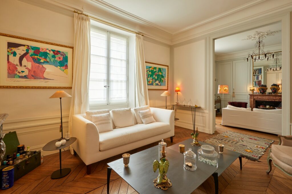 Photographe immobilier - salon d'appartement, parquet en chevron, moulures et collection d'art contemporain