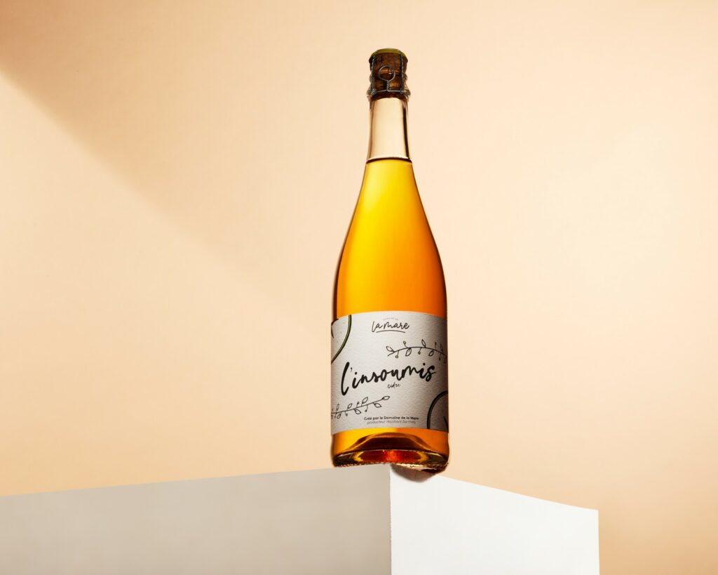 Photographe produit Le Mans - bouteille de cidre L'Insoumis, Domaine de la Mare, mise en scène sur fond dégradé