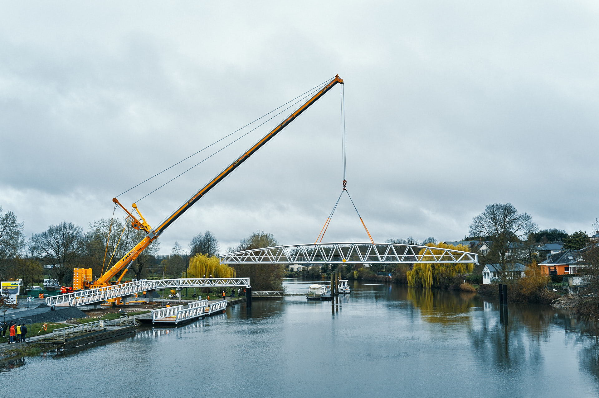 Photographe reportage BTP - levage de la travée arquée de 45 m de la passerelle aluminium au-dessus de la Sarthe par grue Tadano 450 t, La Suze-sur-Sarthe