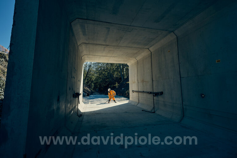 Photographe reportage BTP - ouvrier nettoyant l'intérieur d'un cadre béton préfabriqué à contre-jour, chantier du pont de Semallé (Orne)