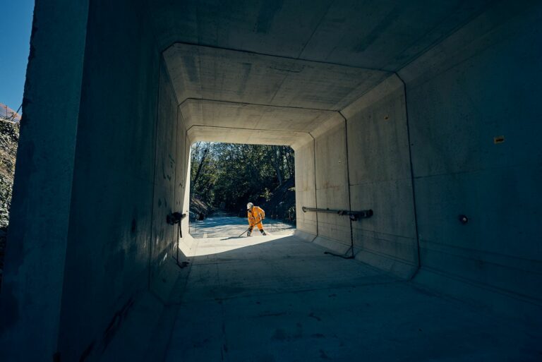 Photographe reportage BTP - ouvrier nettoyant l'intérieur d'un cadre béton préfabriqué à contre-jour, chantier du pont de Semallé (Orne)