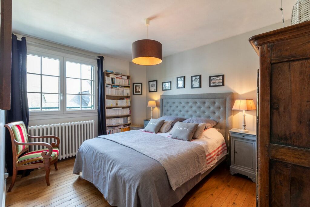 Chambre préparée pour une séance photo : lit fait, tête de lit capitonnée, lampes de chevet allumées