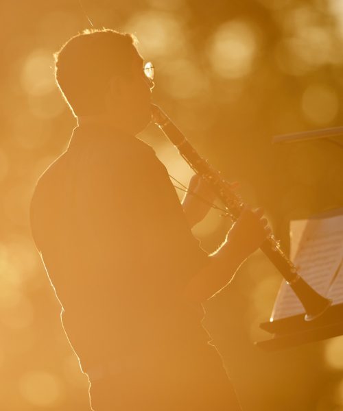 Reportage concert classique - musicien clarinettiste en contre-jour au coucher du soleil